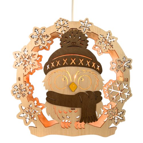 Fensterbild aus Sperrholz. Motiv Wintereule. Eule mit Schal und Puddelm&uuml;tze aus Sperrholz in braun. Au&szlig;enkranz besteht aus verschiedenen Schneeflocken. Hergestellt im Erzgebirge